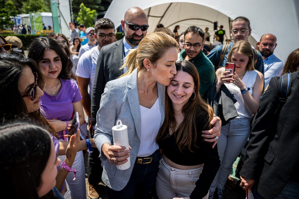 EYE 2023 outdoor events- the image shows President Metsola holding and kissing a girl during outdoor event. They are surrounded by other youth participants