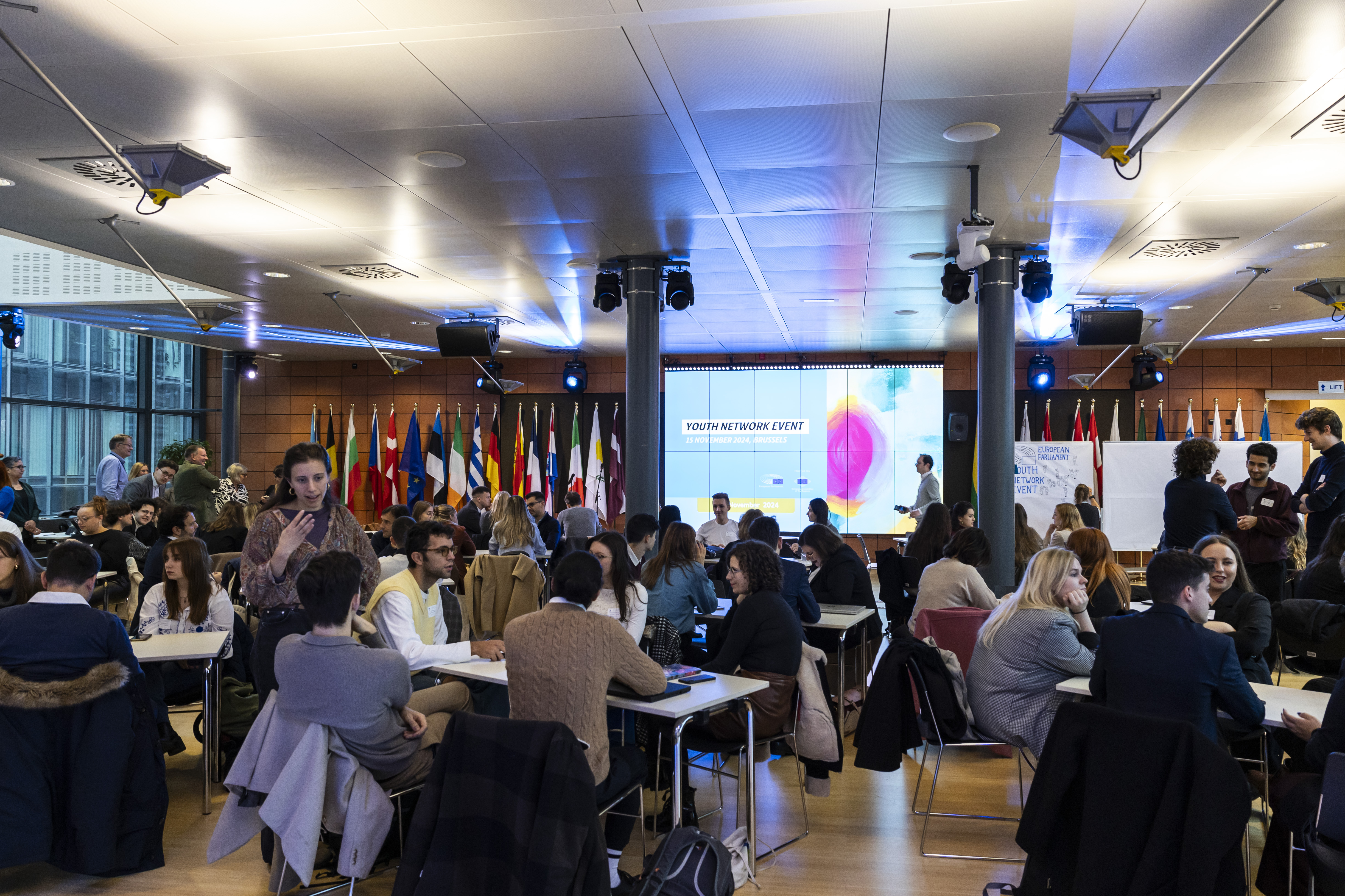 Groups of participants seated on tables and working on a project