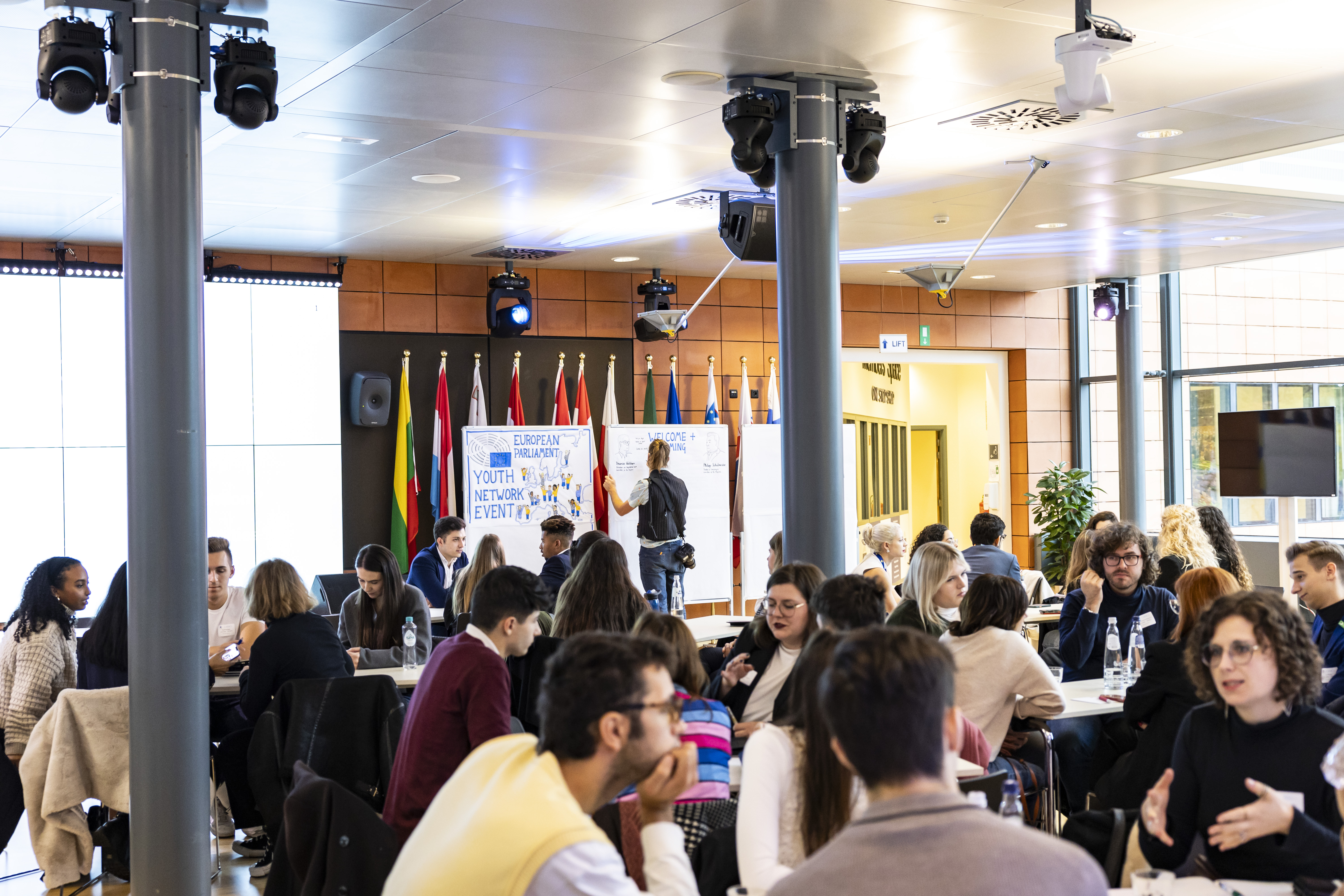 image showing many groups of participants seated on tables and working on projects